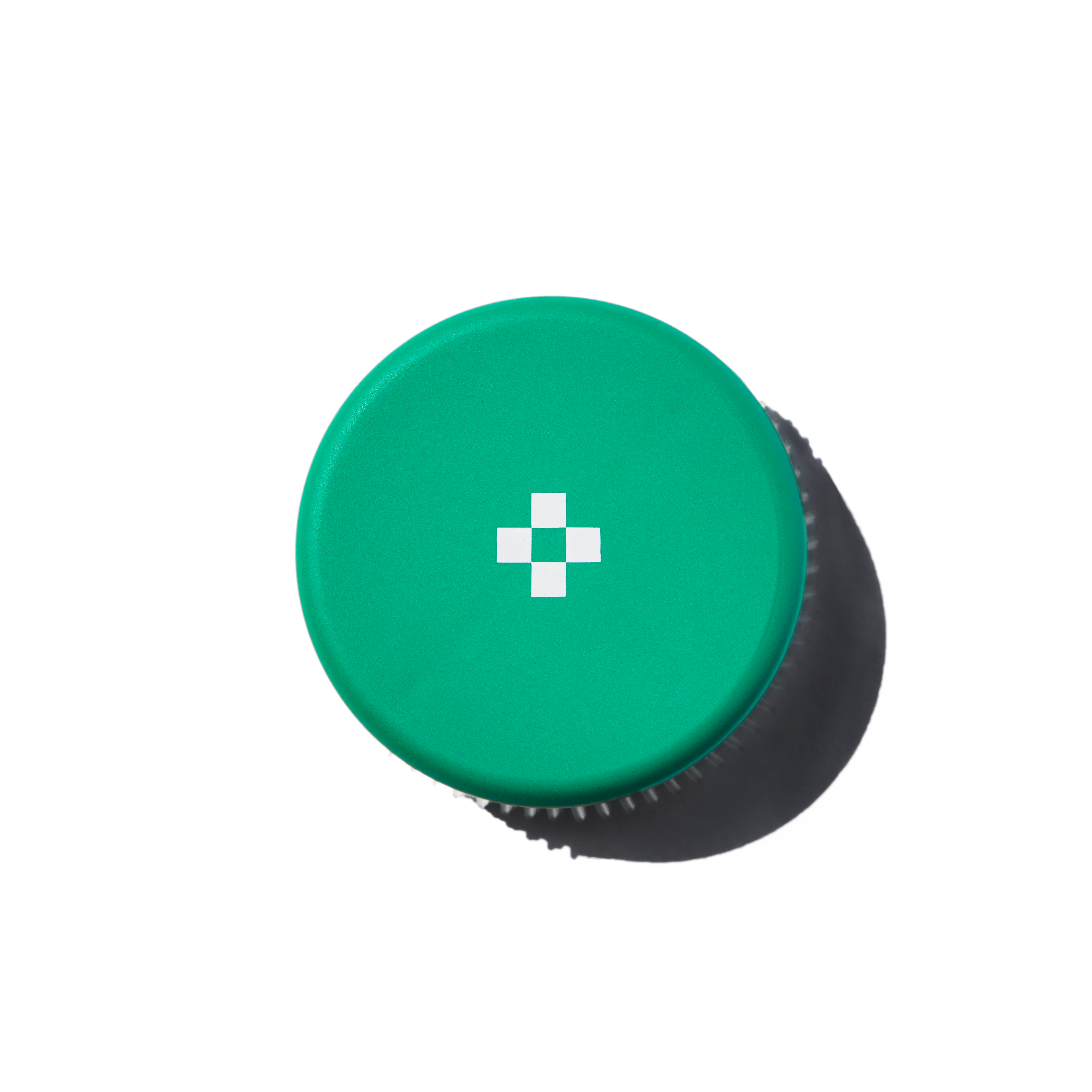 Green cap with a white cross on a white background
